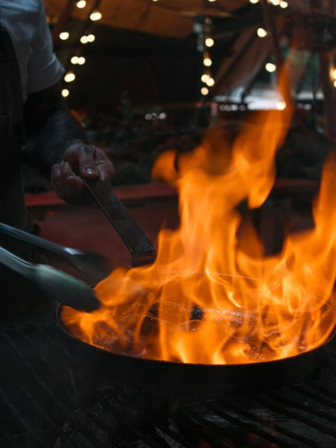 Flames rising from a pan over an open fire